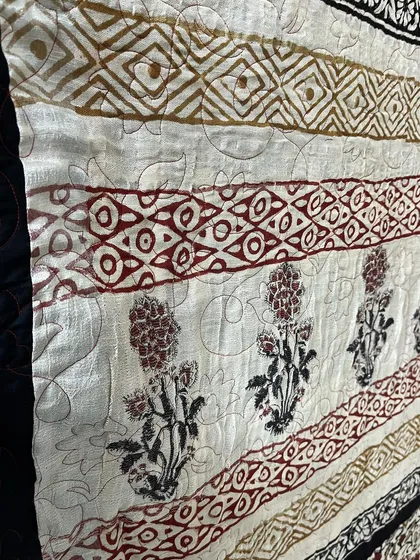 Another close-up showing the delicate floral motifs and how our stitching works around them.