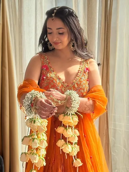 Holding her beautiful floral kaleeras. The entire look, from the makeup to the accessories, is perfectly coordinated for her Haldi ceremony.