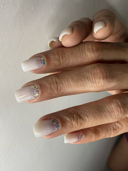 A clean and simple set of white square nails with a subtle glitter fade from the cuticle.