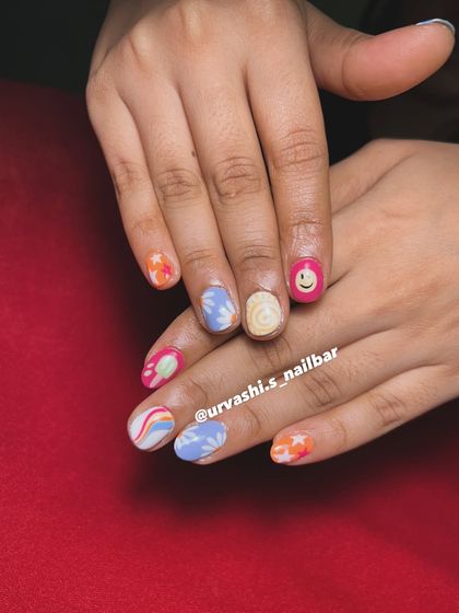 This set screams summer with its mix of fun, hand-painted designs. It includes a smiley face, rainbows, stars, and floral patterns in a bright and cheerful color palette.