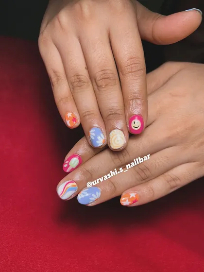 This set screams summer with its mix of fun, hand-painted designs. It includes a smiley face, rainbows, stars, and floral patterns in a bright and cheerful color palette.