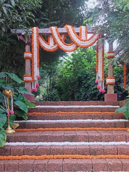 A classic entrance arch for a traditional event. I used rustic wooden pillars and decorated them with beautiful garlands of orange and white marigolds, perfect for an outdoor setting.