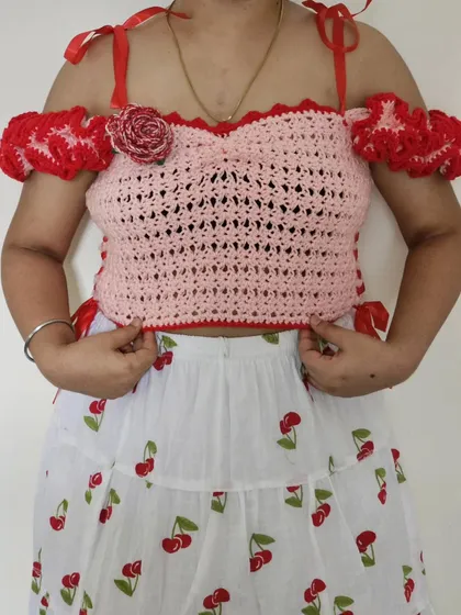 This is the Avery Top, a romantic and feminine piece with off-the-shoulder frilly sleeves and ribbon details.