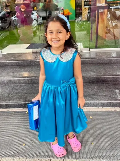 A happy customer shining in her bright blue satin dress. The sequin collar adds just the right amount of sparkle, and the comfortable fit means she can play and party all day long.