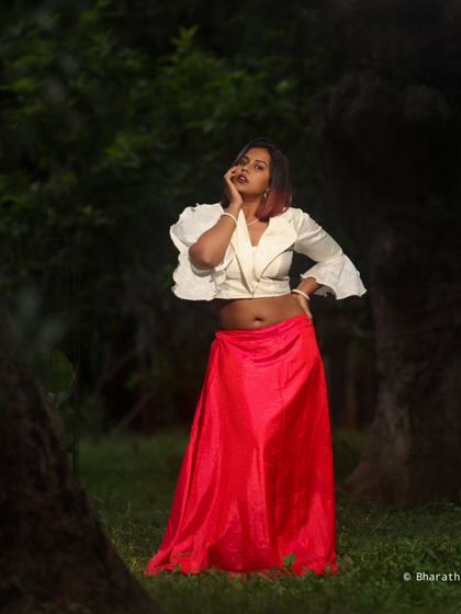 A thoughtful pose in a serene, green environment. The dark, moody lighting adds a touch of drama to the scene.