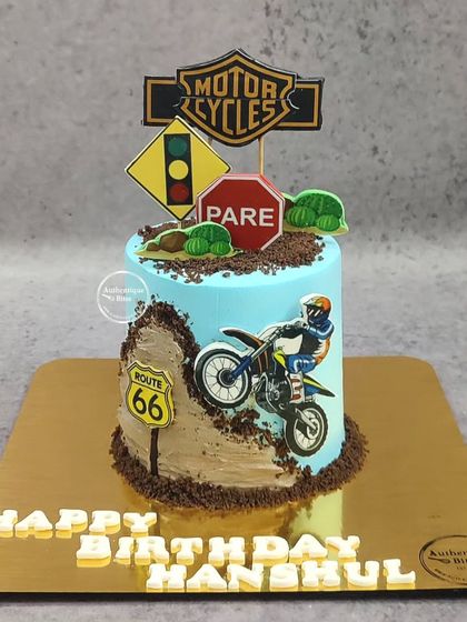 A dirt bike-themed cake for an adventurous birthday. The design features a biker on a dirt track with road signs.