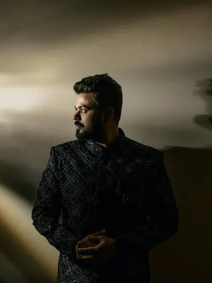 A dramatic portrait of the groom using creative lighting. The light rays create a cinematic effect, making him look like a star in his own movie.