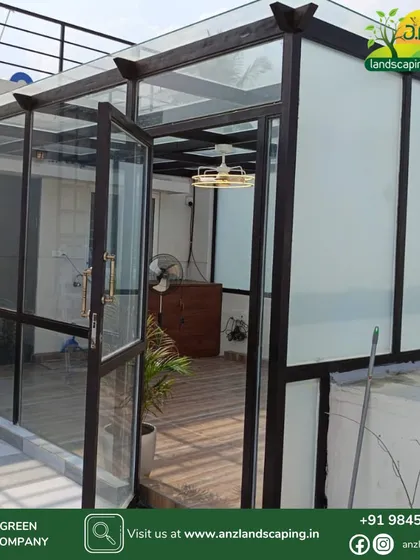 This is an all-weather glass sunroom we built for a client in Bengaluru. It features a robust powder-coated steel frame, a mix of clear and frosted toughened glass for privacy and light, and elegant wooden flooring, creating a comfortable year-round living space.