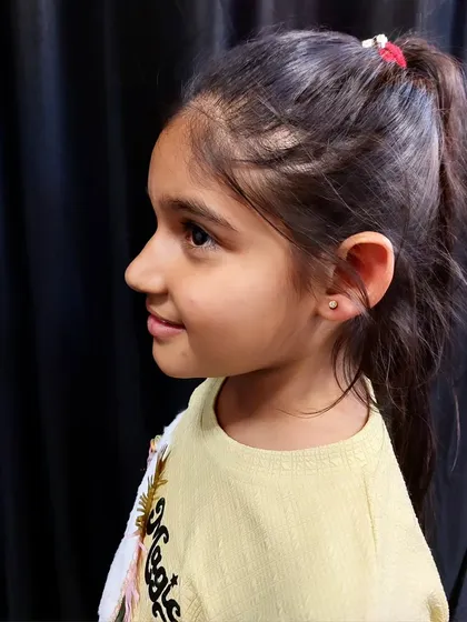 A child's first earlobe piercing done in a safe, calm, and hygienic environment. I only use single-use needles, never piercing guns, to ensure safety and precision for young clients.