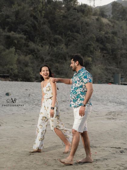 A happy, candid moment of the couple walking on the sandy banks of the river in Rishikesh, showcasing their natural chemistry.