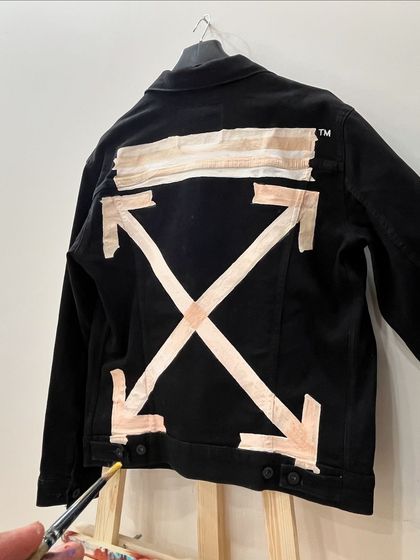 The client wanted the look of tape, but painted. I used fabric paint to create this graphic, industrial-style design on a black denim jacket, showing that inspiration can come from anywhere.