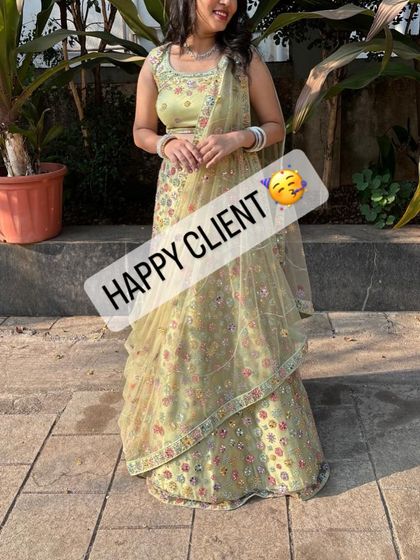 A happy client looking lovely in a light green floral lehenga, a perfect choice for a daytime wedding event.