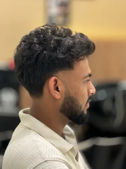 A fresh fade with sharp edges on a client with curly hair. This cut is clean, stylish, and turns heads.