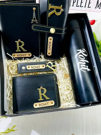 This is my premium leather hamper, an ideal all-in-one corporate gift set. It includes a personalized temperature bottle, a men's wallet, a passport cover, a sunglass holder, and a matching keychain, all made from high-quality black faux leather with custom name and initial engraving.