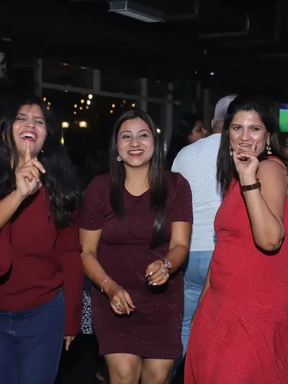 A group of ladies laughing and dancing together.