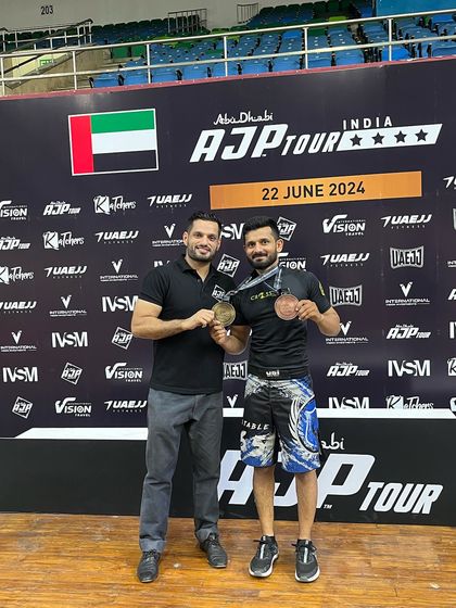 A coach and his fighter celebrating their success at the AJP Tour. This partnership is crucial for success in combat sports.