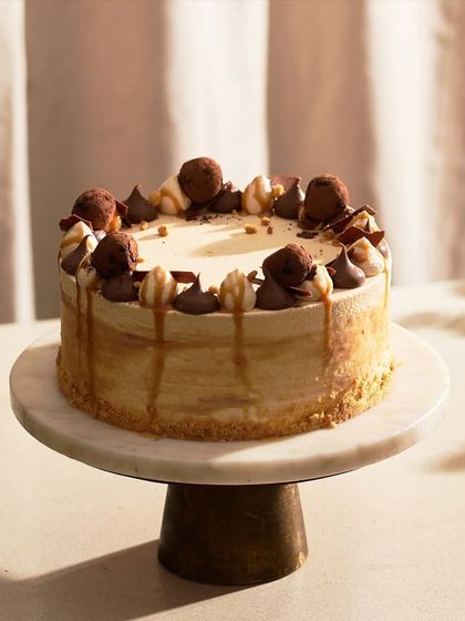 My Caramel Cake, fully decorated and ready for a celebration. It's topped with chocolate truffles, caramel drips, and piped ganache for a rich and varied texture.