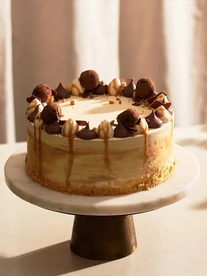 My Caramel Cake, fully decorated and ready for a celebration. It's topped with chocolate truffles, caramel drips, and piped ganache for a rich and varied texture.