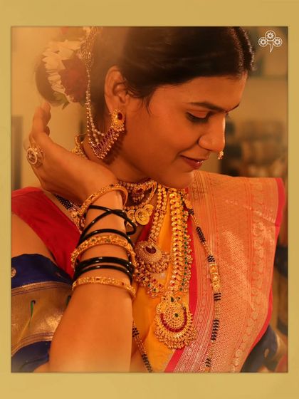 The side profile highlights the beautiful earcuffs and the intricate details of the necklaces.