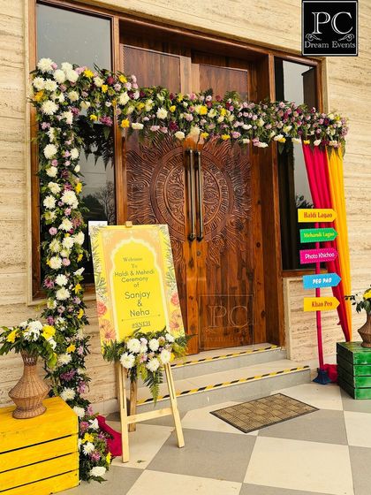A closer look at the vibrant entrance decor, showing the custom welcome sign for the couple and the colorful signs pointing guests to the different activities.