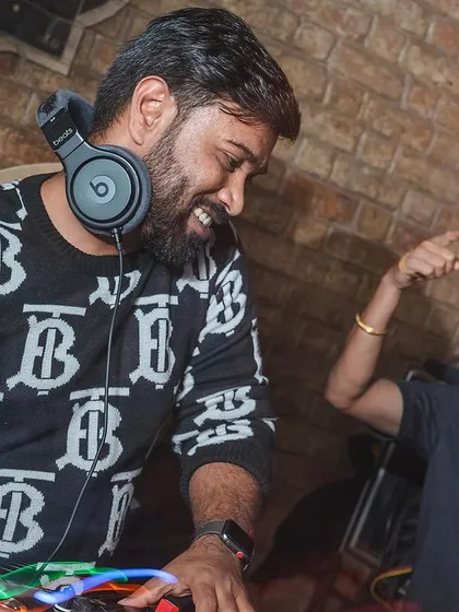 It's not just about playing music; it's about connecting with the crowd. A fun moment behind the decks, sharing a laugh while keeping the party going.