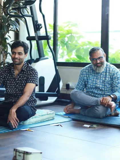 Two men listening with smiles, showing that fathers and partners are also part of the parenting support conversation.