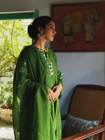 A serene portrait for Baavli, with the model in a beautiful green outfit, framed by a window with soft natural light.