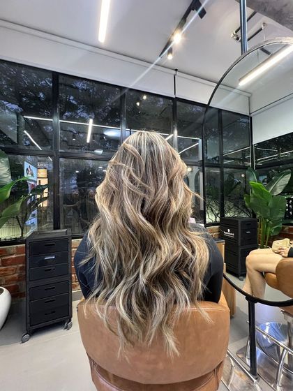 This client's long, wavy hair is the perfect canvas for a lived-in colour. The highlights add brightness and dimension, making the hair look effortlessly beautiful.