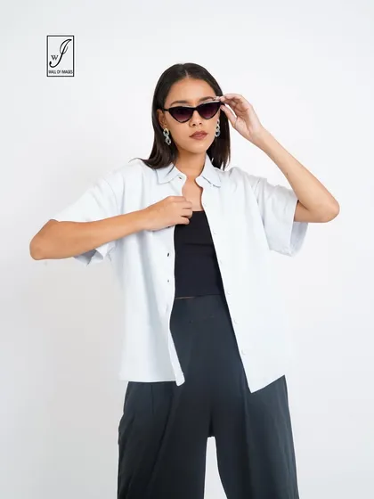 A simple and stylish look with a white shirt over a black top and trousers, perfect for a minimalist brand.