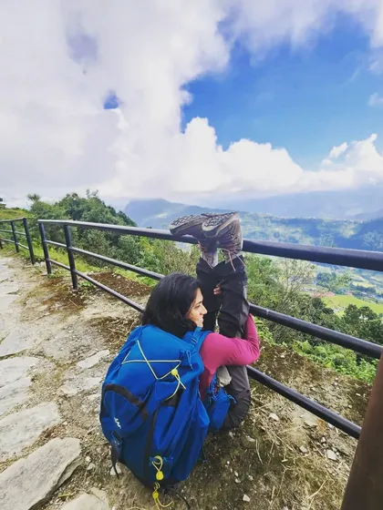 A moment of playful practice, using a railing for support in a leg stretch during our trek.