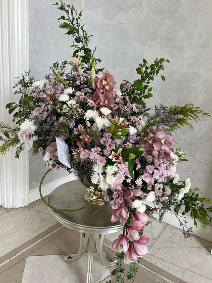 A cascade of pink and white, this arrangement is all about movement and finding its own path. I let the cymbidium orchids and other blooms meander and flow naturally, creating a piece that is both pretty and bountiful.