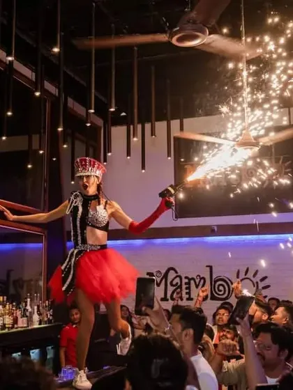 A performer on the bar at Cafe Mambo, enhanced by a sparkler effect. These details make the party memorable and visually exciting.