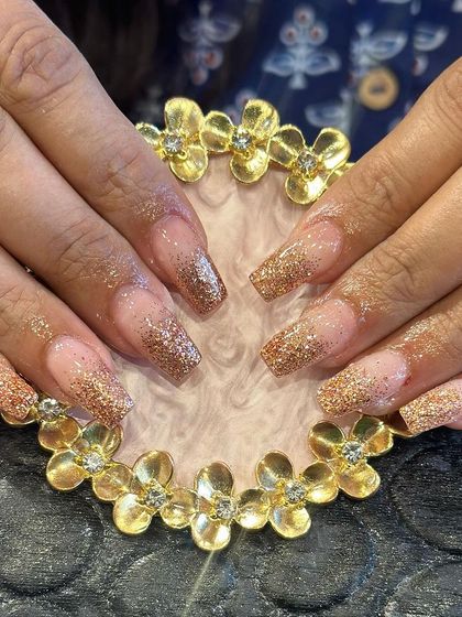 A warm and sparkling set of square-shaped extensions with a bronze glitter ombre effect.