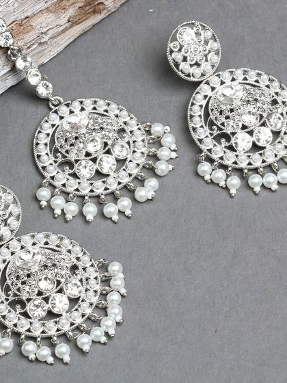 A beautiful silver-plated earring and maang tika set, featuring sparkling stones and delicate pearls.