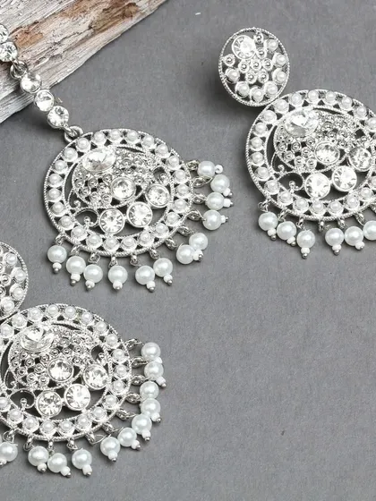 A beautiful silver-plated earring and maang tika set, featuring sparkling stones and delicate pearls.
