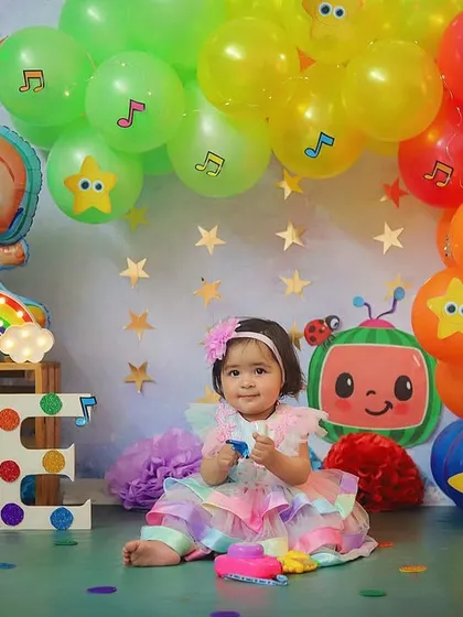 For the little one who loves Cocomelon! This colourful first birthday setup is inspired by the popular show, complete with character balloons and a rainbow cake.
