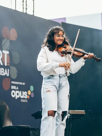 One of our talented violinists performing with grace and confidence at Art Mumbai. We offer lessons in a wide range of instruments, helping each child find their unique musical voice.