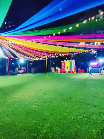 A wide-angle view of the entire event ground, showing the main canopy, the stage in the distance, and the large grassy area ready for the festivities.
