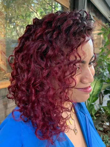 I call this 'Pomegranate Sangria'. I painted these beautiful curly locks with different shades of red and pink, using a little bleach to make the pink pop.