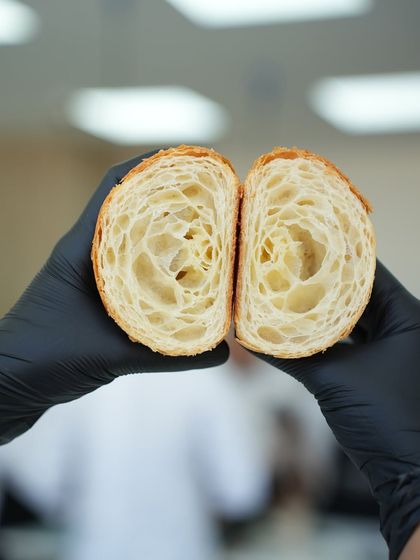Another shot of a perfect croissant cross-section, held up to show the beautiful, open crumb. This is the quality and consistency we train our students to achieve.