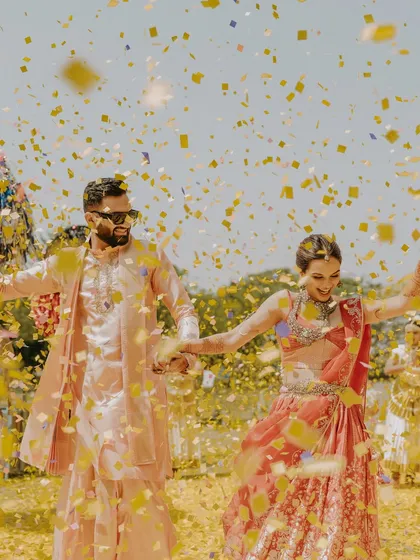 A couple celebrates under a shower of confetti. We believe in creating moments of pure, unadulterated joy that become the highlights of your celebration.