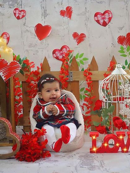 This little sweetheart is ready for Valentine's Day! Her adorable plaid dress and the heart-filled background make for a lovely and festive portrait.