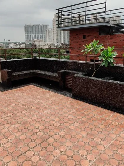 A wide shot of the finished terrace, showing the combination of tiled areas, planters, and built-in seating that provides ample space for large gatherings.