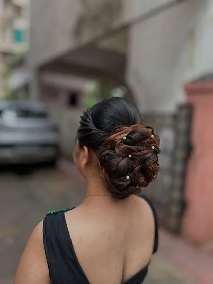 Another angle of the pearl-adorned bun, showcasing the detailed weaving technique involved.