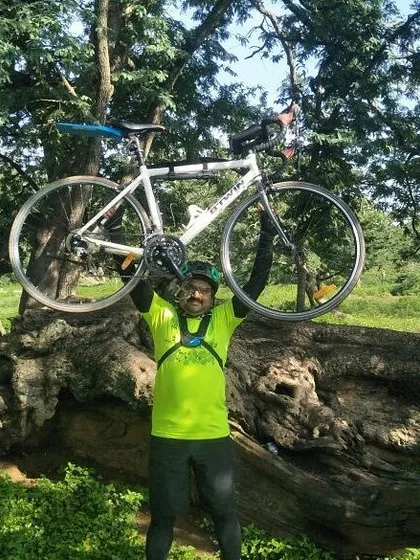 That feeling of accomplishment after conquering a tough section of the trail. This rider is celebrating with his Btwin road bike held high.