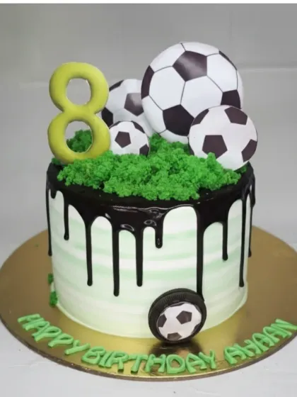A football-themed cake with a butterscotch caramel flavor. This design features a chocolate drip, edible grass, and football toppers for an 8th birthday.