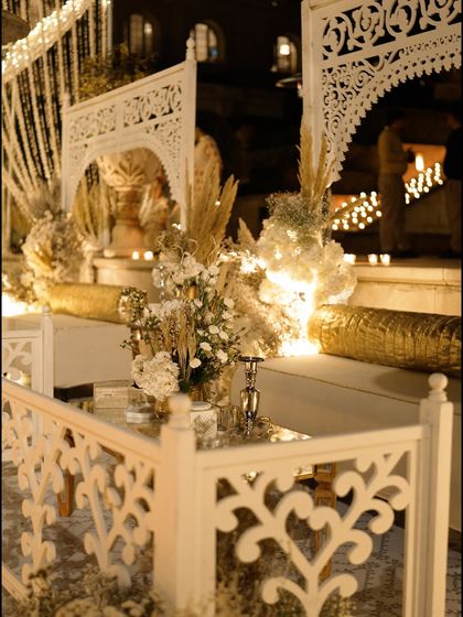 A close-up of the white jaali railings and dried floral arrangements that defined the aesthetic of the Sufi night. The gold cushions added a touch of understated opulence.