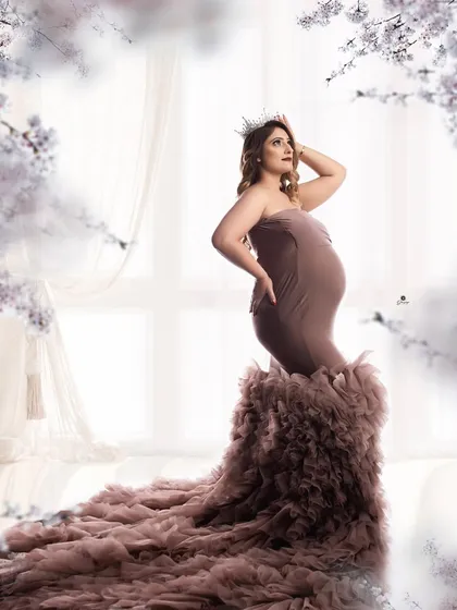 A dreamy and romantic portrait in a dusty mauve ruffled gown. The soft, out-of-focus floral elements and bright background create a magical and ethereal atmosphere.