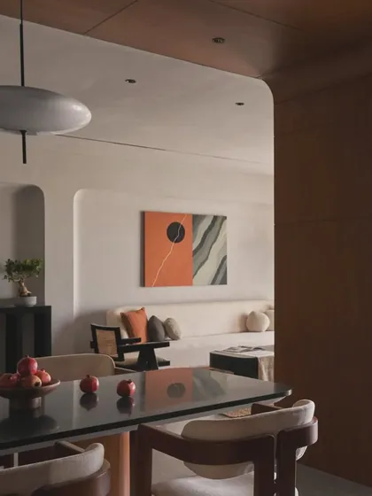 From this angle, you can see how the dining area opens up to the living room. The consistent use of natural materials and a neutral palette creates a cohesive and harmonious home environment.