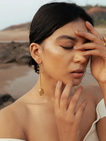 A beautiful, soft-focus shot from the Noupelle Studio campaign. The minimal makeup and simple updo ensure that the delicate gold jewelry remains the focal point.
